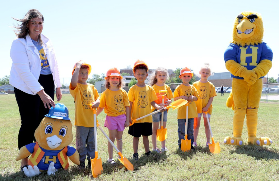 Dr. Krystal Young, left, deputy superintendent of Hutchinson USD 308, and children in the district-operated Lil' Hawks Early Learning Program, break ground on a facility that is expanding the number of birth to Pre-K children served by the district.